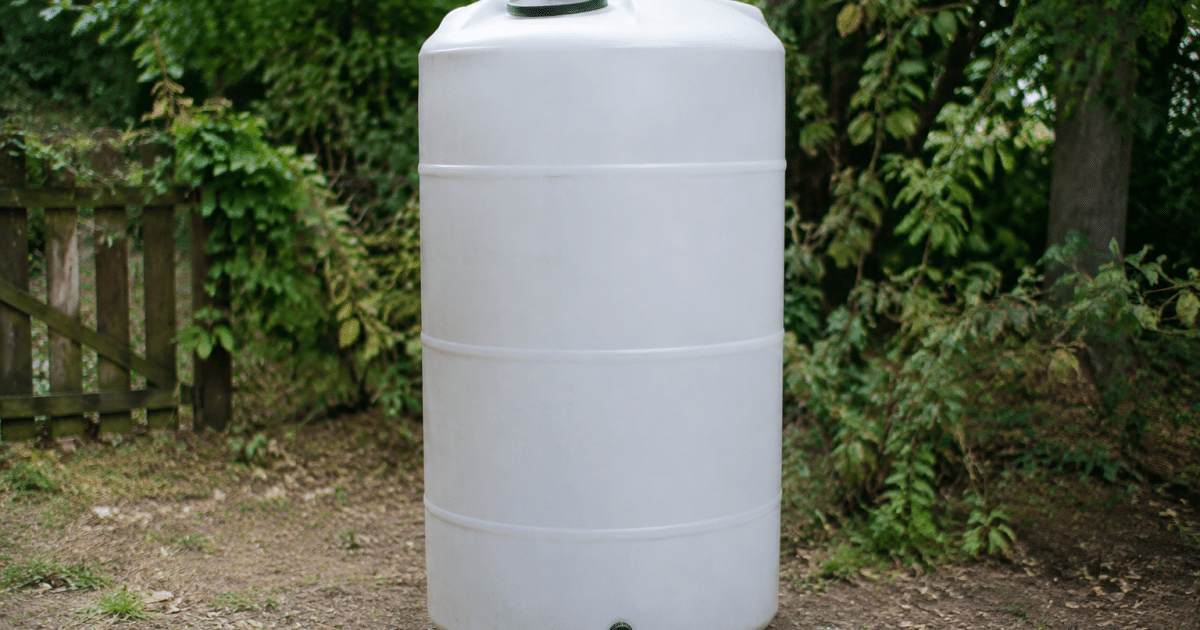 Grand reservoir d'eau cylindrique blanc positionne verticalement au sol