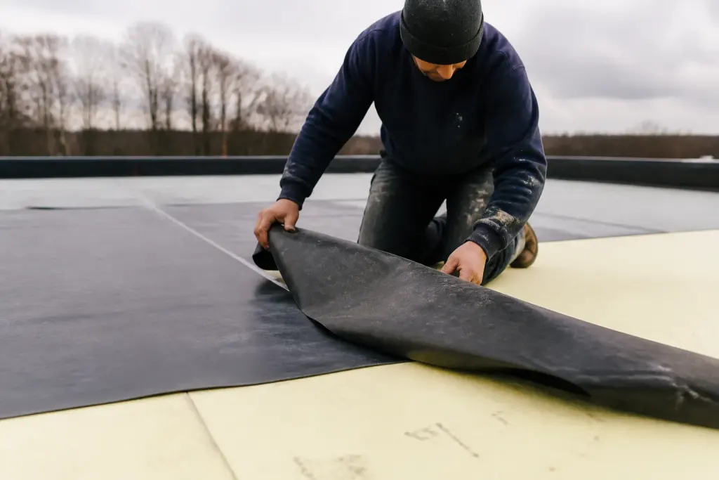 Ouvrier pose membrane EPDM sur isolant polyurethane