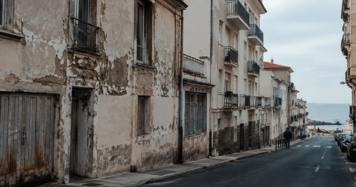 Rue urbaine de Biarritz avec bâtiments délabres et peu de piétons visibles