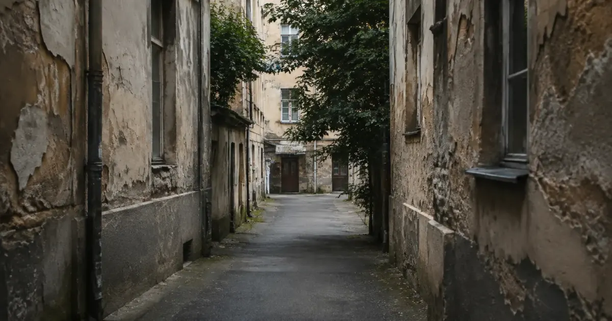 Allee sombre entre immeubles vetustes aux facades craquelees